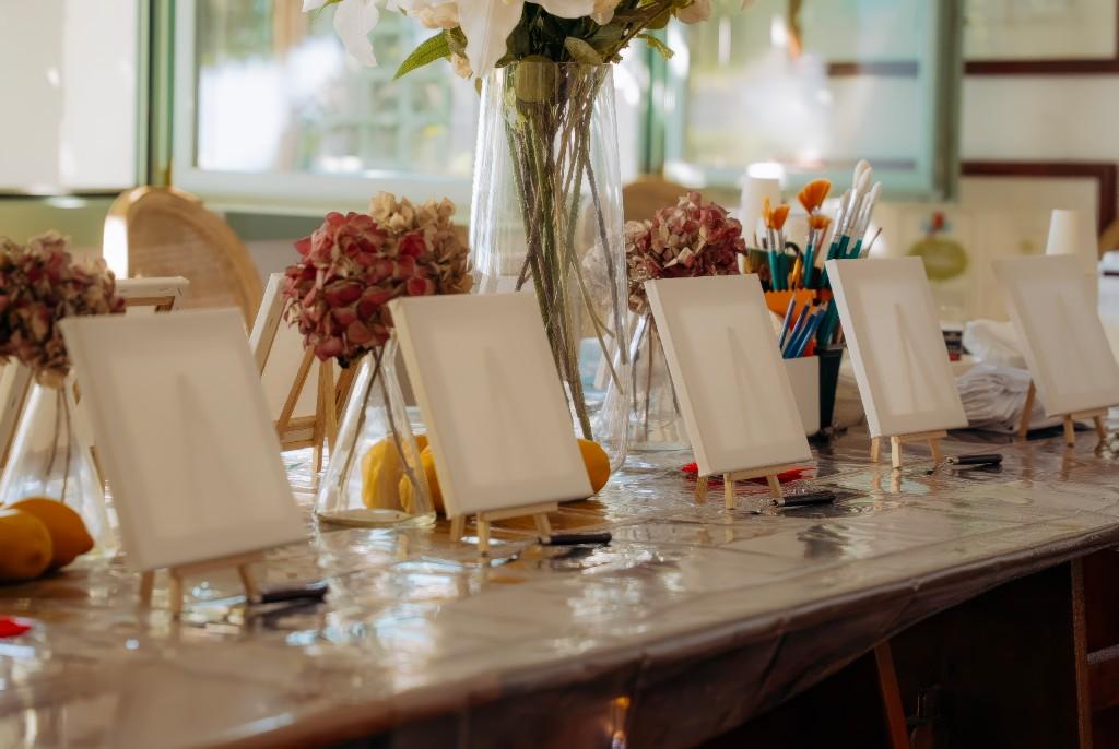 Toiles sur chevalets, fleurs et matériel sur la table d'atelier